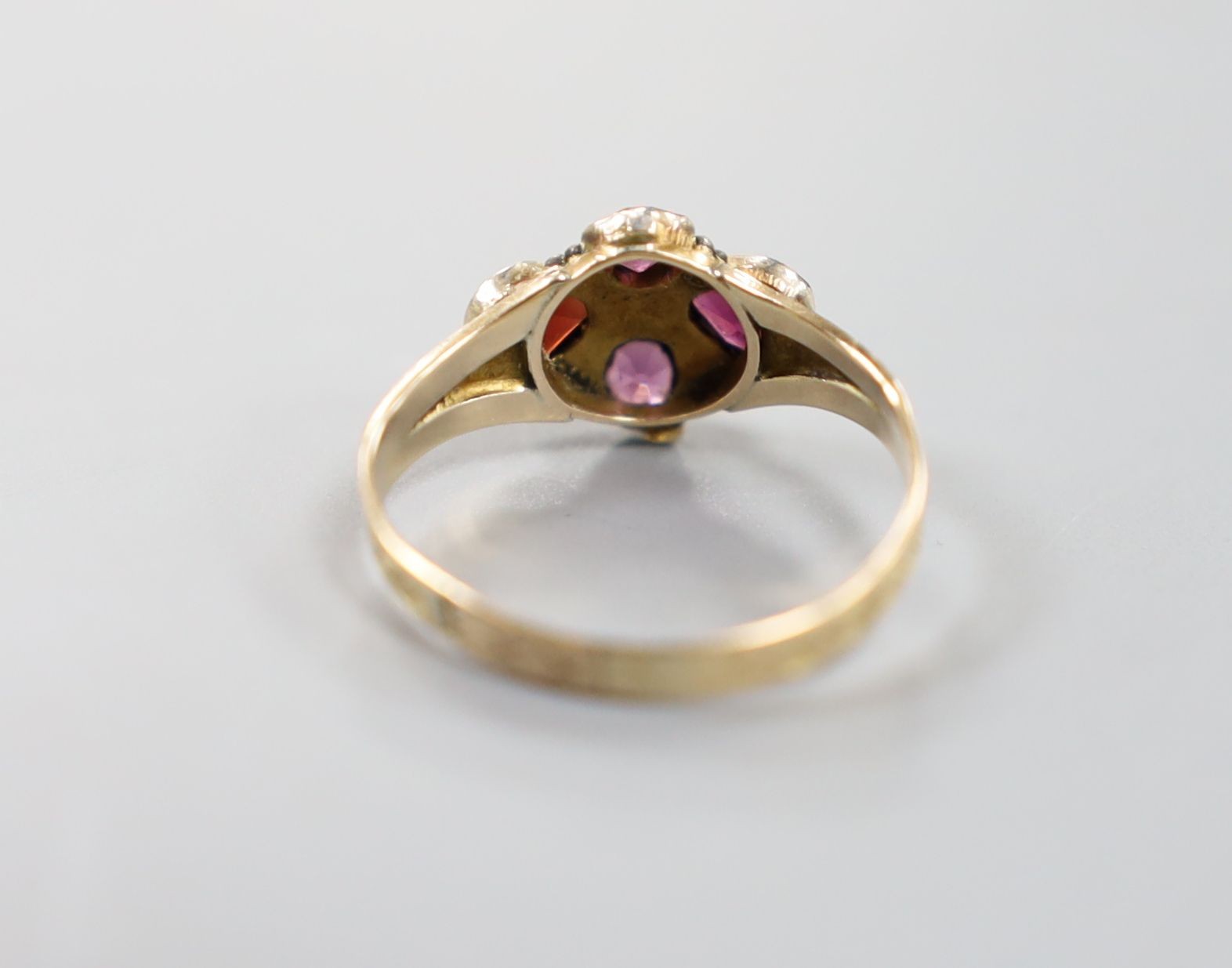 A Victorian 12ct gold and four stone garnet and amethyst set dress ring, size O, gross 1.7 grams.